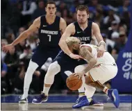  ??  ?? Mavericks forward Luka Doncic (77) fouls Golden State Warriors guard Ky Bowman in the second half Wednesday in Dallas.