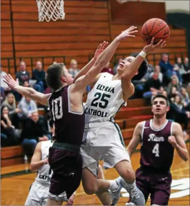  ?? RANDY MEYERS — THE MORNING JOURNAL ?? Elyria Catholic guard Jack Grifffin drives and scores over Connor O’Toole of Rocky River during the first quarter.