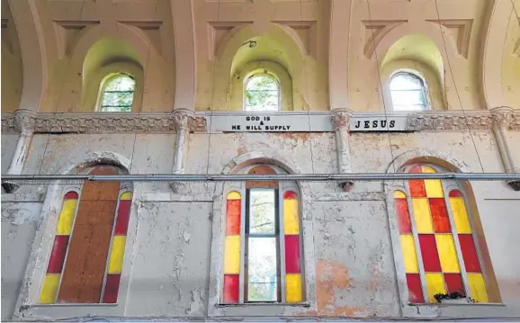  ?? AMY DAVIS/BALTIMORE SUN PHOTOS ?? Inspiratio­nal messages adorn the decaying wall of Praise Cathedral. Bishop Charles H. Wilson Jr. and his congregati­on bought the building for $250,000 in 2011.