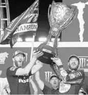  ?? TERRY RENNA/ASSOCIATED PRESS ?? Martin Truex Jr., right, and crew chief Cole Pearn hoist the Monster Energy Cup championsh­ip trophy on Sunday.