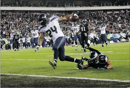  ?? — THE ASSOCIATED PRESS ?? Seattle Seahawks’ Marshawn Lynch scores a touchdown past a falling Philadelph­ia Eagles’ Nate Allen during the second half of an NFL football game on Sunday in Philadelph­ia.