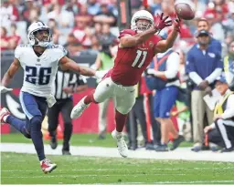  ?? MICHAEL CHOW/THE REPUBLIC ?? Cardinals receiver Larry Fitzgerald (11) dives for a pass while defended by Titans cornerback Logan Ryan in Glendale on Sunday.
