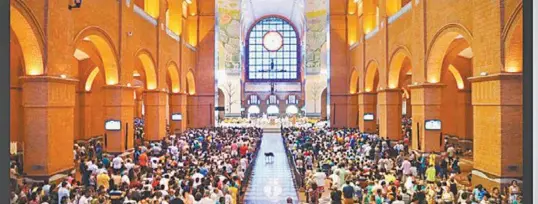  ?? ROVENA ROSA/AGÊNCIA BRASIL ?? Um cãozinho atravessa a nave da Basílica de Aparecida em uma das missas do Dia da Padroeira: 200 mil fiéis foram ao Santuário Nacional, no interior paulista, ontem