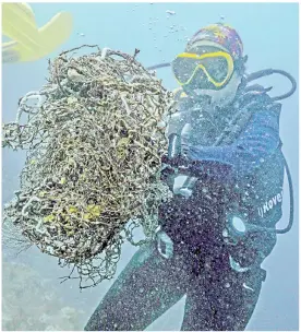  ??  ?? A diver collecting discarded fishing nets off the coast of Chonburi province. — AFP photos