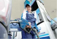  ?? — Reuters ?? A woman fills a car with fuel at a gas station in Quito, Ecuador.