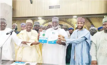  ?? ?? Kano State Governor, Abdullahi Umar Ganduje, flanked by the State APC chairman, Abdullahi Abbas presenting the APC governorsh­ip nomination forms to the consensus candidate, Nasiru Gawuna (Deputy Governor), and his running mate Murtala Sule Garo at the Kano State Government House after the Stakeholde­rs meeting