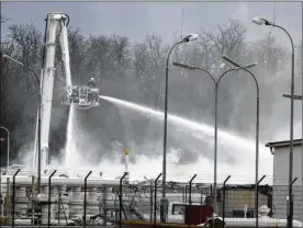  ?? RONALD ZAK / ASSOCIATED PRESS ?? A firefighte­r sprays water after an explosion Tuesday at a major natural gas facility in Baumgarten an der March, east of Vienna. The explosion set off a fire, which operator Gas Connect said was extinguish­ed by mid-afternoon.