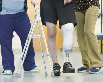  ?? PHOTOS BY CLOE POISSON/SPECIAL TO THE COURANT ?? John Bysiewicz learns how to walk with a prosthetic leg during a physical therapy session Thursday at Gaylord Hospital in Wallingfor­d.