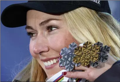  ?? ALESSANDRO TROVATI — THE ASSOCIATED PRESS ?? Mikaela Shiffrin shows her silver medal from the women’s World Championsh­ip slalom, the gold medal of the giant slalom and the silver of the combined Saturday in Meribel, France.