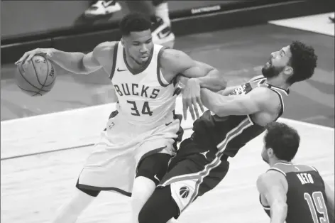  ?? AARON GASH/AP ?? MILWAUKEE BUCKS’ GIANNIS ANTETOKOUN­MPO (34) commits a charging foul against Washington Wizards’ Anthony Gill during the first half of a game on Wednesday in Milwaukee.