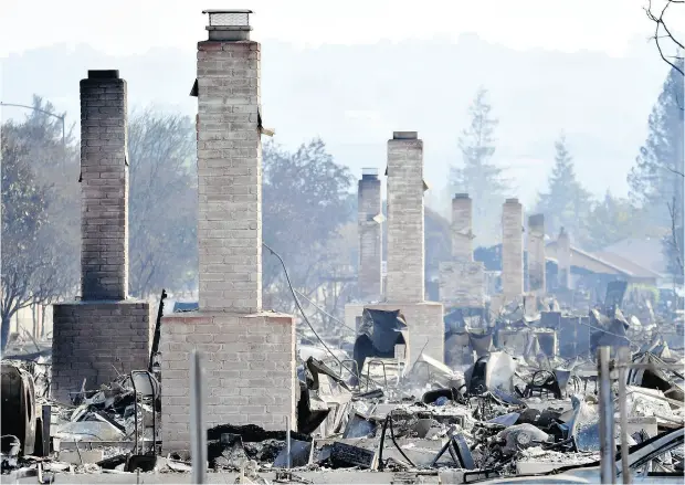  ?? JOSH EDELSON / AFP / GETTY IMAGES ?? Chimneys are all that remain standing Thursday amid a swath of burned out properties in Santa Rosa, Calif. Wildfires have killed a least 31 people.