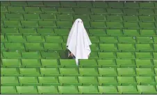  ?? (File Photo/AP/Kerstin Joensson) ?? A man dressed as a ghost stands on the empty tribune on March 12, 2020, prior the Europa League round of 16 first leg soccer match between Linzer ASK and Manchester United in Linz, Austria. The match was being played in an empty stadium because of the coronaviru­s outbreak.