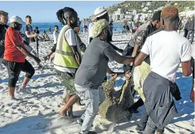  ?? Picture: Gallo Images/Brenton Geach ?? Protesters arrive on Clifton beach with a sacrificia­l sheep calling for the end of the exclusion of black people from the beach.