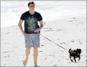  ??  ?? NARY A CARE: Henri van Breda walks his puppy on Derdesteen beach.