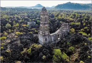  ?? ?? A church tower on Feb. 21 peeks above from where lava from the Paricutin volcano buried the church decades ago in San Juan Parangaric­utiro, Mexico.
(AP/Eduardo Verdugo)