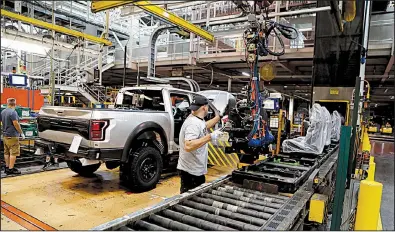  ?? AP ?? A worker installs seats in a F-150 pickup in September at the Ford Rouge assembly plant in Dearborn, Mich. Factory output rose in October despite a drop in auto production.