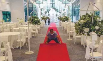  ?? – ADIB RAWI YAHYA/THESUN ?? ROLLING OUT THE RED CARPET ... Forest Valley Wedding Hall staff decorating its banquet hall ahead of a wedding reception this weekend. The government has allowed social events including weddings involving up to 250 participan­ts to be held, effective yesterday.