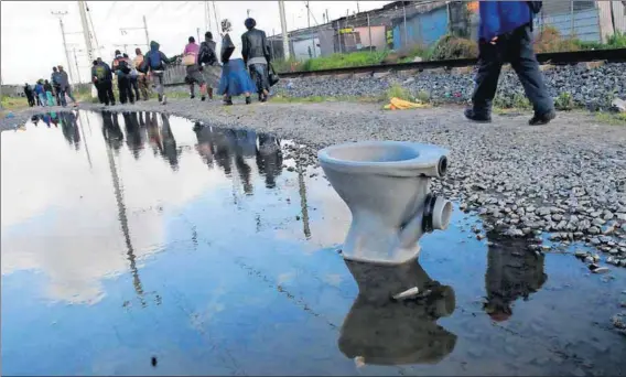  ??  ?? A Drain on our Dignity: In his award-winning photograph­ic series Masixole Feni (left) documents conditions in Mfuleni outside Cape Town where poor sanitation and flooding are a way of life