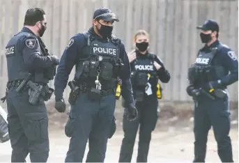  ?? DAN JANISSE ?? Masked Windsor police officers are shown on a call in downtown Windsor on Thursday.