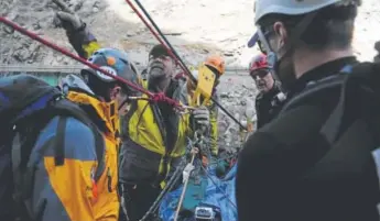  ?? Seth McConnell, Denver Post file ?? Alpine Rescue Team member Ric Ondrusek, second from left, directs several others as they prepare a high-line system before transporti­ng a “patient” over a river during ice-climbing rescue training in Cold Creek Canyon near Golden in 2014.