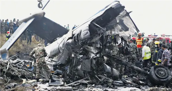  ??  ?? Rescue workers comb the burnt and mangled wreckage of the Us-bangla Airlines turboprop plane that crashed with 71 people on board as it approached Nepal’s capital Kathmandu