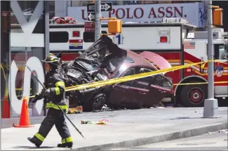  ?? The Associated Press ?? A smashed car sits on the corner of Broadway and 45th Street in New York’s Times Square after driving through a crowd of pedestrian­s at lunchtime on Thursday. The driver is in custody.