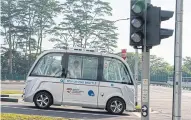  ??  ?? ABOVE A Navya autonomous electric passenger bus waits at a signal light.