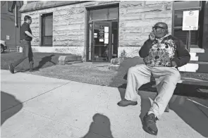  ?? DORAL CHENOWETH/COLUMBUS DISPATCH ?? Leon Davis, right, smokes a cigarette as Joseph Mccabe, the man accused of assaulting him, walks into the Perry County Courthours­e on Monday. The men are neighbors in New Lexington. Davis said that on July 5, 2020, Mccabe and other men launched a racist attack on him.