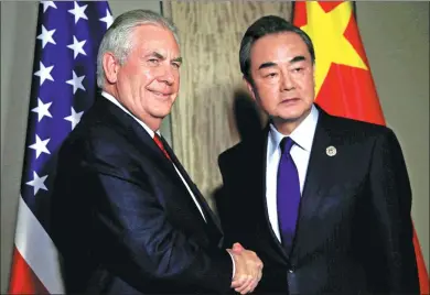  ?? ROMEO RANOCO / REUTERS ?? Foreign Minister Wang Yi greets US Secretary of State Rex Tillerson before their talks in Manila, Philippine­s, on Sunday.