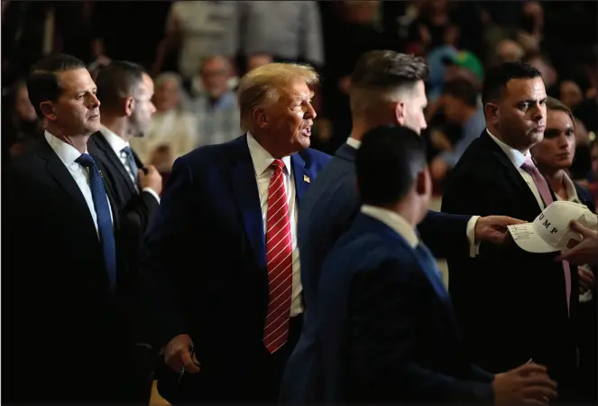  ?? CHARLIE NEIBERGALL / ASSOCIATED PRESS ?? Republican presidenti­al candidate Donald Trump signs autographs Saturday after speaking during a commit to caucus rally, in Clinton, Iowa.