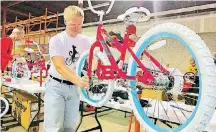  ?? [PHOTO BY CARLA HINTON, THE OKLAHOMAN ARCHIVES] ?? Steve Smith, of Oklahoma City, a member of the Oklahoma Bicycle Society, assembles a girl’s bicycle that he placed on a bicycle stand during the Salvation Army’s 2017 “Buck$ 4 Bikes” bicycle assembly event in Oklahoma City.