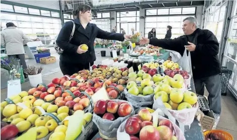  ?? PHOTOS BY JULIE JOCSAK/POSTMEDIA NETWORK PHOTO ?? Lindsey Bateman of Niagara-on-the-Lake buys some apples and pears from Joe Hozjan of Town and Counrty Farms who was at St. Catharines market selling his locally grown food in this photo from 2011.