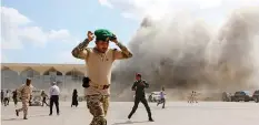  ?? | Reuters ?? A SECURITY officers flee after explosions hit Aden airport, on the arrival of the newly-formed Yemeni government in Aden, yesterday.