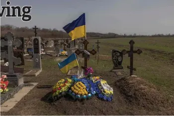  ?? Photos by Roman Pilipey — AFP ?? The grave of a Ukrainian local soldier for whose re-burial people gathered on Oct 5, 2023 in a cafe that later was hit by the Russian strike, at a cemetery in the village of Groza, Kharkiv region, amid the Russian invasion of Ukraine.