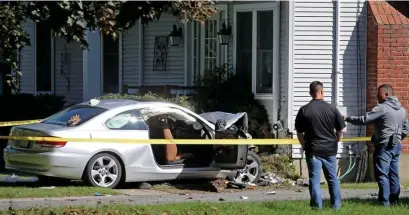  ?? STuART CAHiLL / HeRALd sTAFF ?? FATAL IMPACT: Investigat­ors check the scene in Needham where a car struck a house, killing two passengers in their 80s.