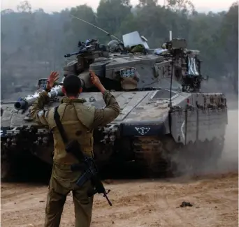  ?? (Reuters) ?? A SOLDIER guides a tank at the Gaza border.