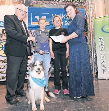  ?? RP-FOTO: JÖRG KNAPPE ?? SSV-Chef Klaus Dieter Grefges (li.) und SSV-Geschäftsf­ührerin Gabi Freund-Schneider (re.) gratuliert­en Nina Windhausen (2. v. li.) und Sabrina Reetz mit Australien Sheperd Cooper.