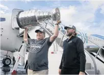 ?? DIRK SHADD/AP ?? Lightning owner Jeff Vinik, left, holds the Stanley Cup as captain Steven Stamkos looks on after the team arrived in Tampa on Tuesday.