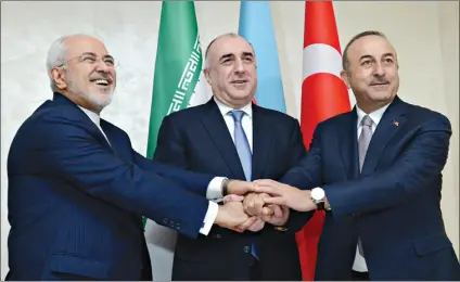  ??  ?? Foreign Ministers of Azerbaijan Elmar Mammadyaro­v (M), Iran Mohammad Javad (L) and Turkey Mevlut Cavusoglu (R) shake hands prior to the trilateral meeting.