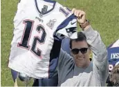  ?? STEVEN SENNE/AP ?? Tom Brady shows off his recovered Super Bowl jersey this week before throwing out the first pitch at Fenway Park.