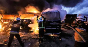  ??  ?? عناصر من الدفاع المدني يخمدون النيران في عدد من الشاحنات عقب ضربات جوية روسية على مستودع بالقرب من معبر باب الهوى الحدودي بين سوريا وتركيا