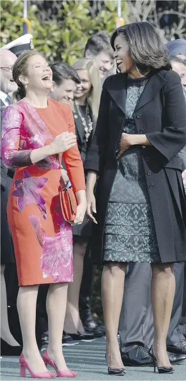  ?? OLIVIER DOULIERY / GETTY IMAGES ?? First Lady Michelle Obama, right, and Sophie Grégoire-Trudeau share a laugh
during a ceremony at the White House on Thursday in Washington, D.C.