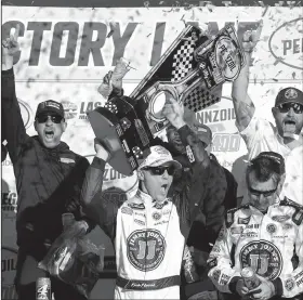  ?? File Photo/AP ?? Kevin Harvick (center) hoists a trophy after winning a NASCAR Cup series auto race March 4 in Las Vegas.