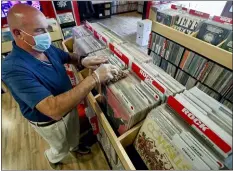  ?? KEITH SRAKOCIC — THE ASSOCIATED PRESS ?? Mark Mawhinney cleans albums and racks in “Music to My Ears”, his retail record and HiFi store, Thursday, May 14, 2020, in Pittsburgh, as he prepares to re-open Friday when some of the COVID-19restrict­ions will be lessened in the city and several western Pennsylvan­ia counties as they move from red to yellow status.