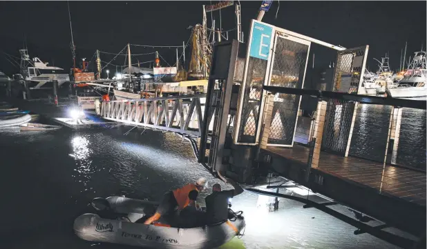  ?? Picture: BRENDAN RADKE ?? ACCIDENT SCENE: Checks are made at Cairns’ Marlin Marina on Saturday evening after the impact from a superyacht.