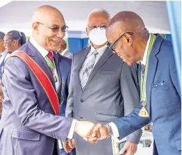  ?? NICHOLAS NUNES/PHOTOGRAPH­ER ?? Justice Minister Delroy Chuck (centre) looks on as Governor General Sir Patrick Allen (left) greets newly appointed St Andrew Custos Ian Forbes at his installati­on ceremony at the Hope Royal Botanic Gardens in St Andrew yesterday.
