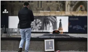  ?? (AP/The Canadian Press/Justin Tang) ?? A person looks on at a portrait of former Prime Minister Brian Mulroney that was left by the Centennial Flame on Parliament Hill on Friday as Canadians mourn his death at the age of 84, in Ottawa, Canada.