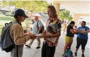  ?? Jessica Phelps/staff file photo ?? Robert Wagner, with Nextgen Texas, helps UTSA students register to vote. Senate Bill 1111 requires voters to have a physical residentia­l address.