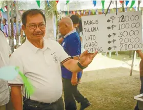  ?? FACEBOOK PAGE FOTOS FROM SEC. EMMANUEL PIÑOL’S ?? NEW RATES. Agricultur­e Secretary Emmanuel Piñol shows the new prices of fish at a market in Tagbilaran City, Bohol.