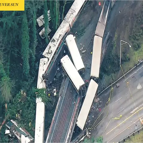  ?? KOMO-TV / VIA THE ASSOCIATED PRESS ?? Cars from a derailed Amtrak train that was travelling from Seattle to Portland, Ore., hang over a highway on Monday. At least three people were killed and 77 others taken to hospital after the train derailed during its inaugural run, spilling passenger cars onto Interstate 5.